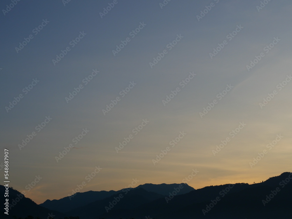 Silhouette of mountain with blue sky at sunrise  ,Horizon began to turn orange with gold color in tropical areas, Thailand
