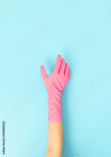 woman in dishwashing gloves holding dish sponge doing cleaning