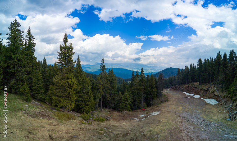 Mountain descent through forest in Rhodope Mountains against sky in weather. Panorama, top view
