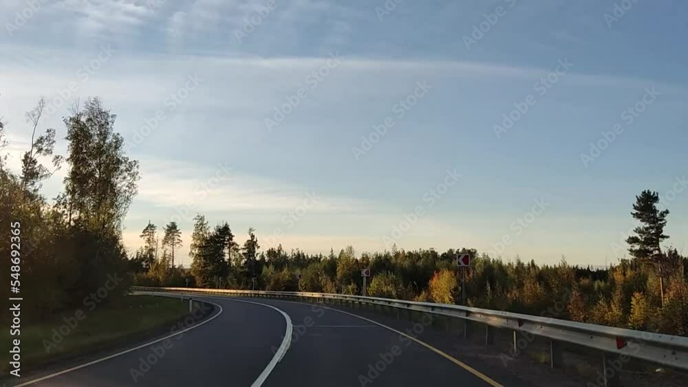 Autumn road turns and the sun is blinding. Glimpses of sunlight through the trees in motion.
Autumn road turns and the sun is blinding. Glimpses of sunlight through the trees in motion.
