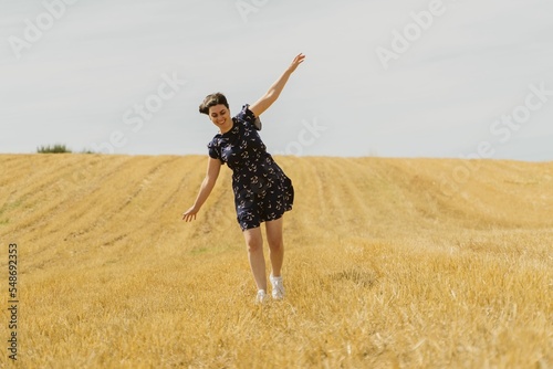 Beautiful shot of a female walking in the middle of yellow fields in Rio de Onor, Braganca, Portugal photo