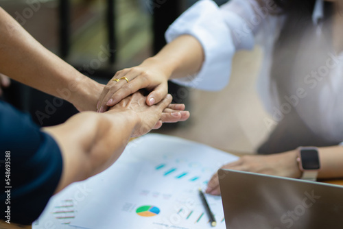 Happy multiethnic successful business team giving high fives gesture as they laugh and cheer on their success