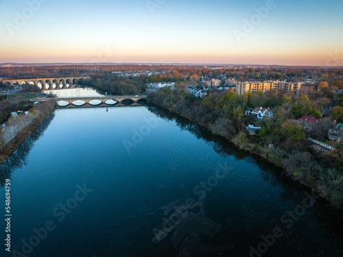 Drone view of a river with a bridge surrounded by buildings in New Brunswick, Rutgers, Hub City, USA