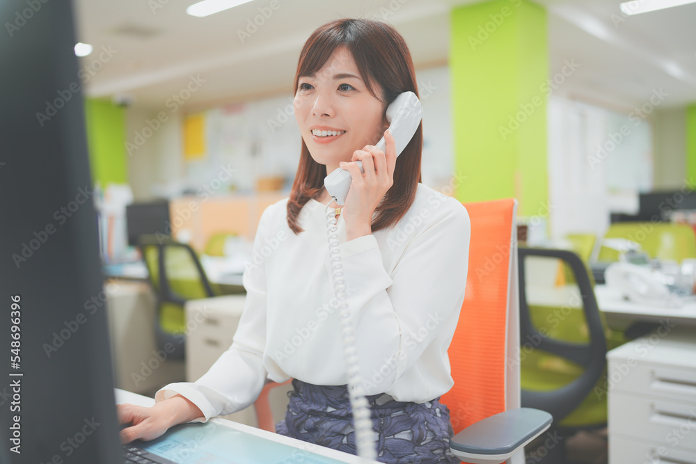オフィスで電話応対をする女性 Stock 写真 | Adobe Stock