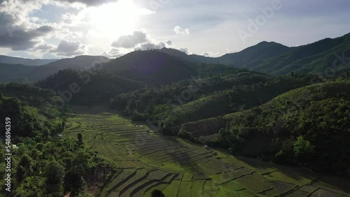 Aerial view of terraced agriculture field among greenery mountains with the blue cloudy and sunlight in the northern of Thailand, Omkoi district, Chiang Mai. photo