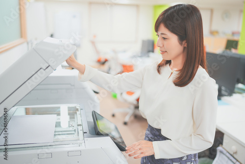 Foto 職場でコピー機を操作する女性