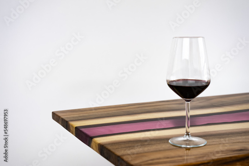 Coffee table, living room table. Resin handmade wood table. On a white background. Glass of whisky and glass of wine on the table.