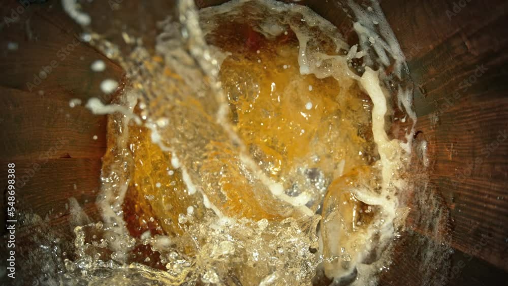 Super Slow Motion Shot of Pouring Fresh Beer into Old Wooden Barrel at 1000fps.