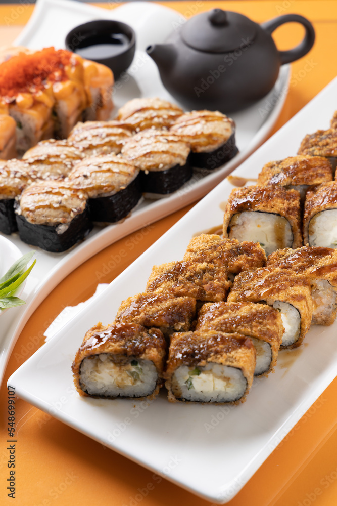 sushi and rolls on an orange background sushi and rolls on an orange background