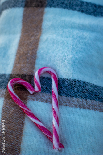 Corazón solitario de san Valentín hecho con bastones de caramelo navideños sobre una calentita manta en un frío día de invierno. photo