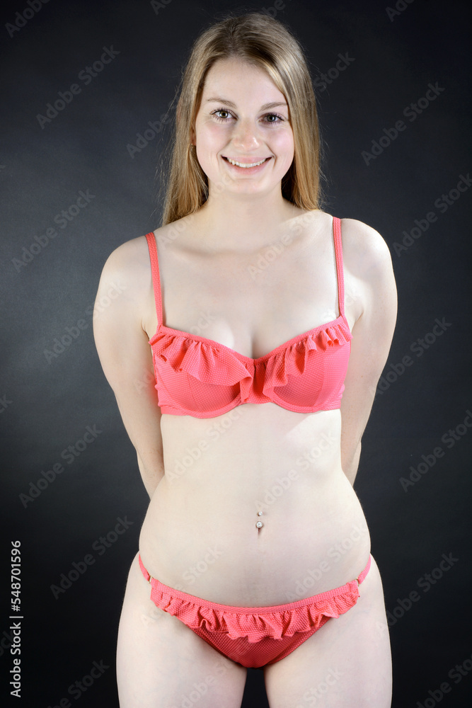 Beautiful young woman posing in red bikini in studio
