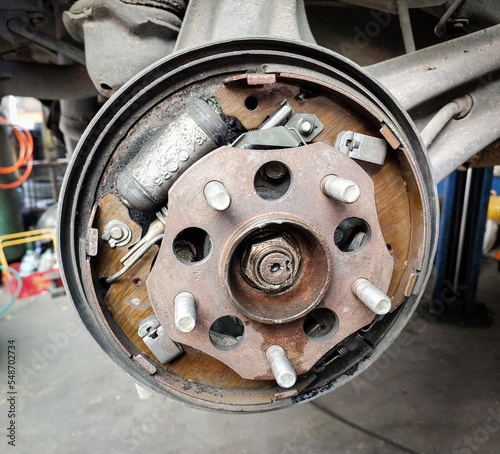 Car maintenance in a garage. The drum brake of a vehicle. The mechanic engineer is working on the brake.