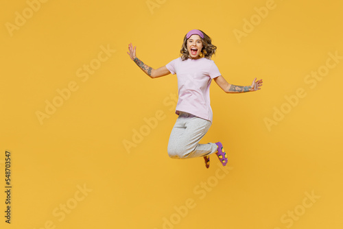 Full body young woman she wear purple pyjamas jam sleep eye mask rest relax at home jump high with outstretched hands like flying isolated on plain yellow background studio portrait Night nap concept