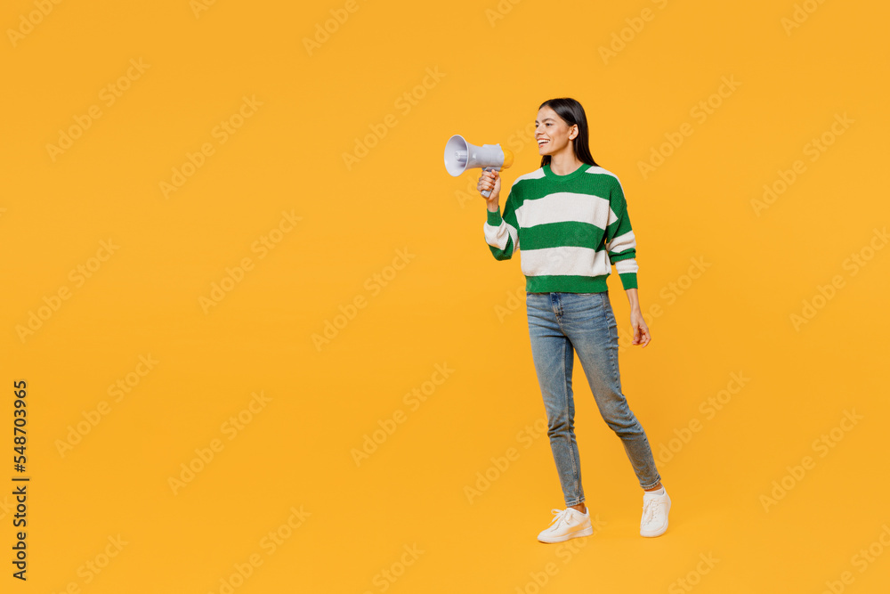 Full body young latin woman wear casual green knitted sweater hold scream in megaphone announces discounts sale Hurry up isolated on plain yellow background studio portrait People lifestyle concept. Full body young latin woman wear casual green knitted sweater hold scream in megaphone announces discounts sale Hurry up isolated on plain yellow background studio portrait People lifestyle concept.