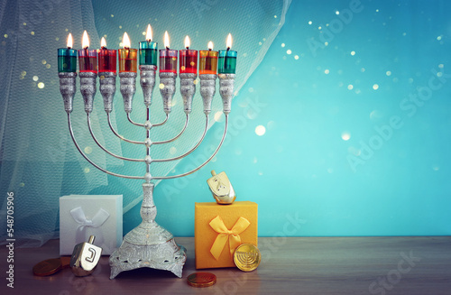 Image of jewish holiday Hanukkah with menorah (traditional candelabra) and colorful oil candles photo