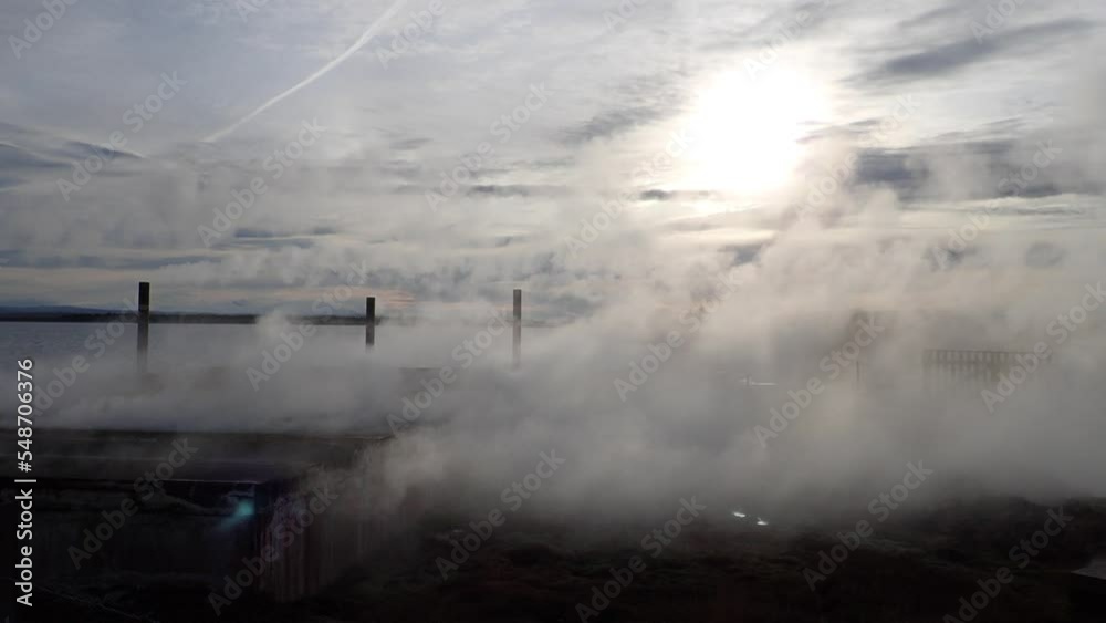 Silhouette of late evening light with heavy fog moving over grassy hill and lake Silhouette of late evening light with heavy fog moving over grassy hill and lake