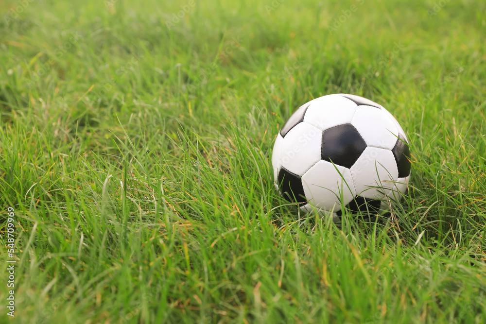 Dirty soccer ball on green grass outdoors, space for text Dirty soccer ball on green grass outdoors, space for text