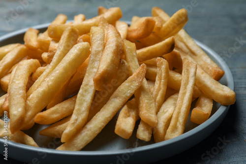 Tasty french fries on wooden table, closeup