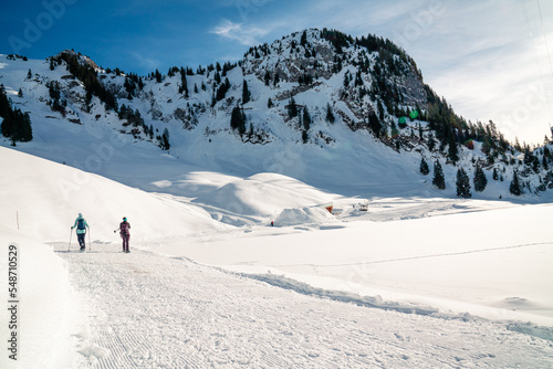 Schneeschuhlaufen im Winter. Ein Paar in den Bergen in einer verschneiten Winterlandschaft. Wintersport ausüben in der Schweiz. © Sebastian