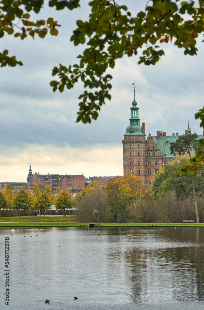 Frederiksborg castle park with created lake, in the background the castle. Colors