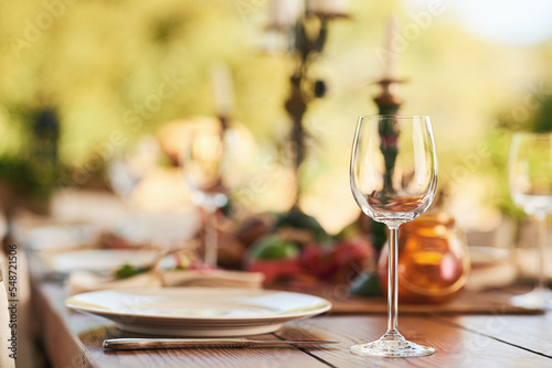 Restaurant, wine glass and table for dinner, party or thanksgiving celebration with luxury, winery and hospitality industry, Patio, plate and outdoor eating experience for lunch or drink background photo