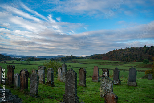 Gothic cemetery in Argyll Scotland sunrise. old graveyard early morning blue sky few clouds