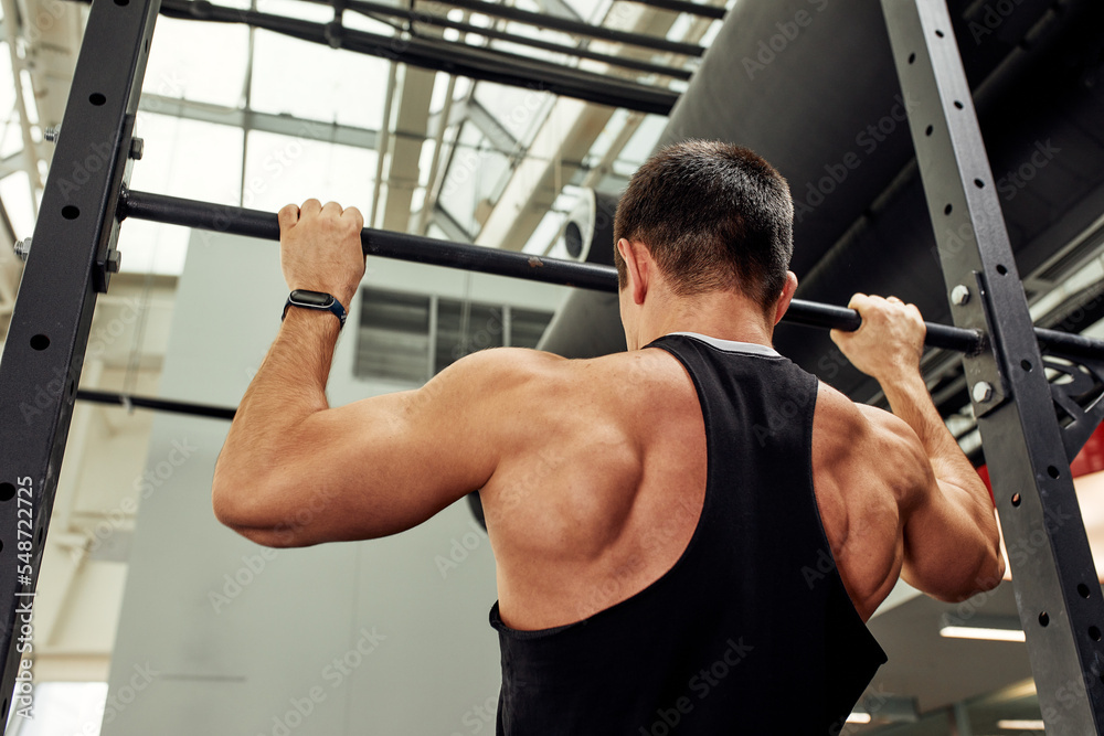 work with own weight, the athlete does exercises on the uneven bars. work with own weight, the athlete does exercises on the uneven bars.