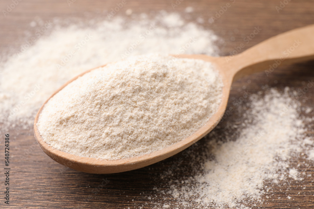 Spoon with quinoa flour on wooden table, closeup Spoon with quinoa flour on wooden table, closeup