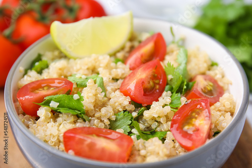 Delicious quinoa salad with tomatoes, parsley and lime, closeup