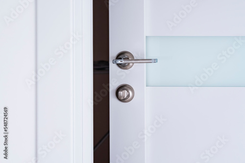 White wooden door. open doors with chrome handles . Conceptual welcome, invitation to enter or new opportunity