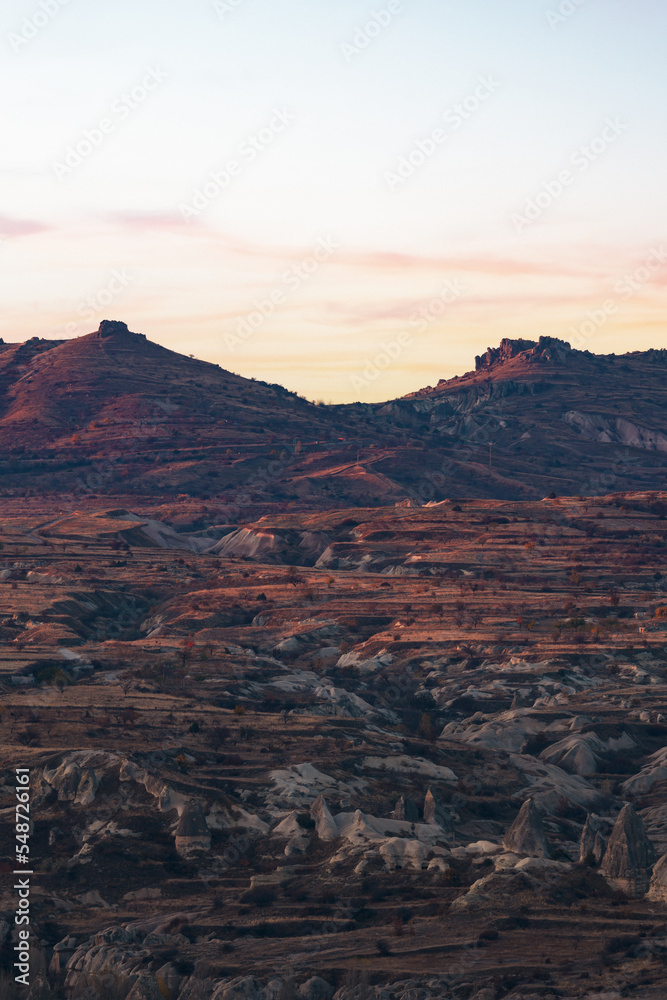 Fototapeta premium Stunning view of some rock formations in the Red & Rose Valley in Cappadocia during a beautiful sunrise. Goreme, central Antolia, Turkey.