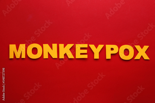 Word Monkeypox made of paper letters on red background, top view