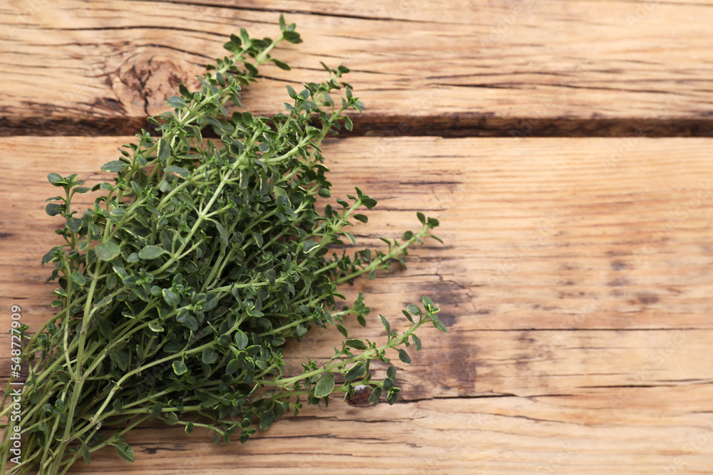 Bunch of aromatic thyme on wooden table, top view. Space for text Bunch of aromatic thyme on wooden table, top view. Space for text