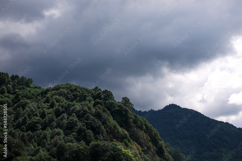 Picturesque view of mountains under beautiful gloomy sky with fluffy clouds
