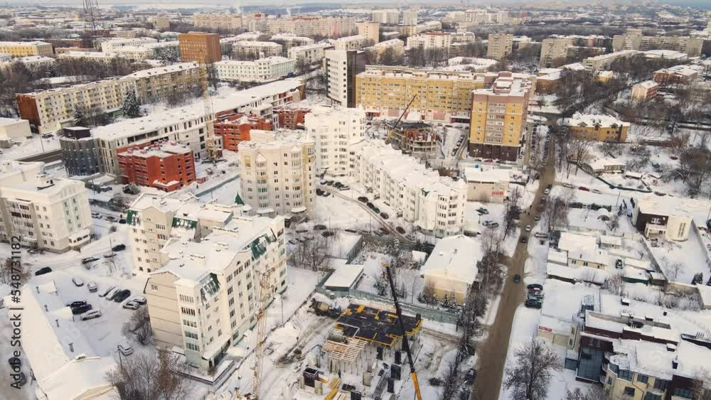 Bird's eye view of a snow-covered urban residential area in winter. New buildings in a modern metropolis. Solution of the housing problem. City of Vladimir, Oktyabrsky district. UHD 4K. Bird's eye view of a snow-covered urban residential area in winter. New buildings in a modern metropolis. Solution of the housing problem. City of Vladimir, Oktyabrsky district. UHD 4K.
