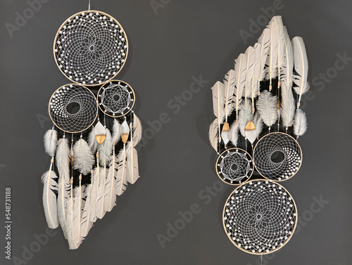 Close-up white feathers dreamcatcher craft on gray background