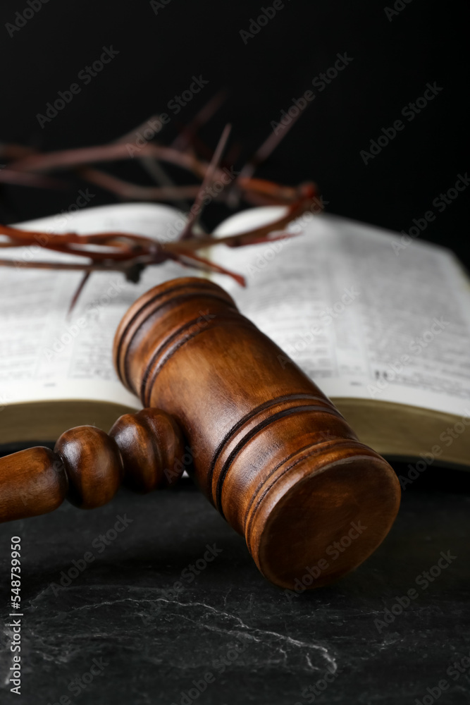Judge gavel, bible and crown of thorns on black table
