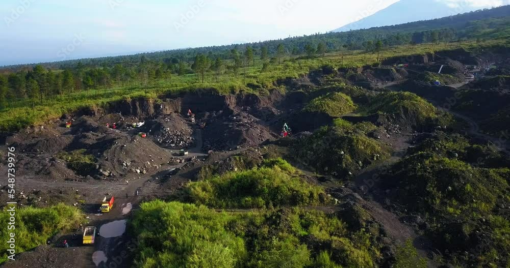 Orbit drone shot of illegal sand mining activities that cause environmental damage on the slope of mountain. Excavators are digging and trucks are transporting mining products - Merapi Volcano Orbit drone shot of illegal sand mining activities that cause environmental damage on the slope of mountain. Excavators are digging and trucks are transporting mining products - Merapi Volcano