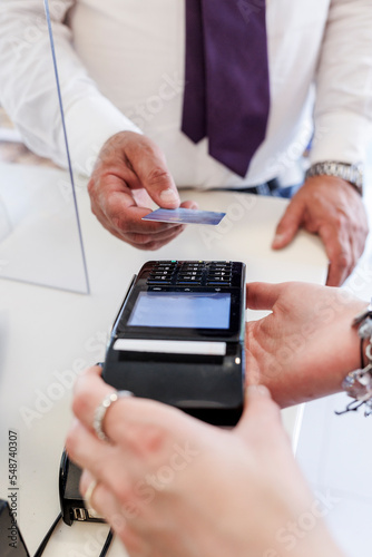 Dettaglio del pagamento con carta di credito da parte di un cliente alla cassa di un negozio.