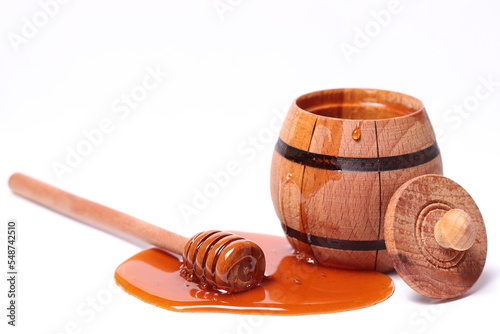 Dark honey from a barrel on a white background
