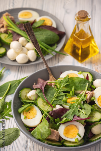 Keto dish - healthy green salad with arugula, tuna, mozzarella and eggs. 