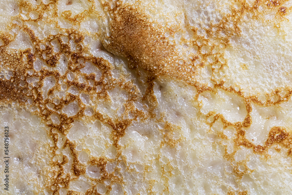 Pancake surface texture and pattern. Close-up of thin hot pancakes in a plate. Traditional rustic food. Graphic resource.