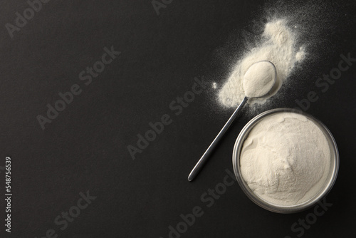 Bowl and spoon of agar-agar powder on black background, flat lay. Space for text