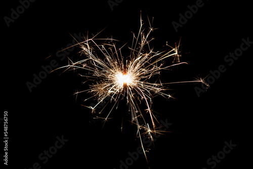 Burning sparkler isolated on black background. Fireworks theme. Light effect and texture.