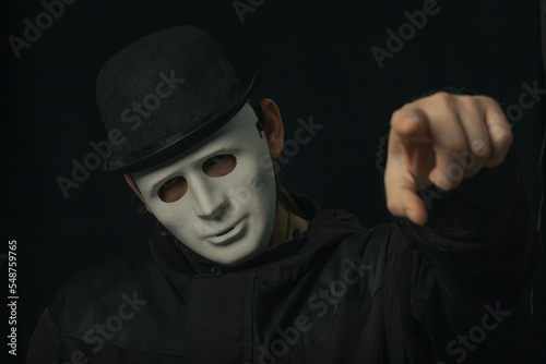 Scary figure with creepy mask and hat in the dark