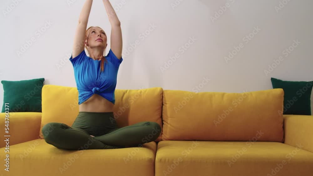 Adult ginger skinny woman meditating on yellow sofa Adult ginger skinny woman meditating on yellow sofa