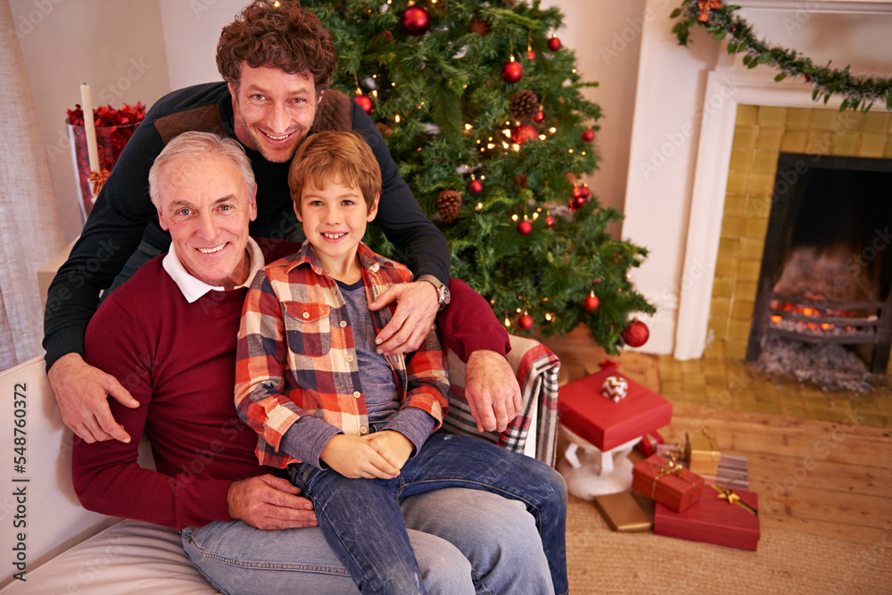 Portrait of a grandfather, father and child at a christmas event relaxing on sofa together. Happy, smile and senior man in retirement sitting with dad and boy kid at festive xmas celebration at home.