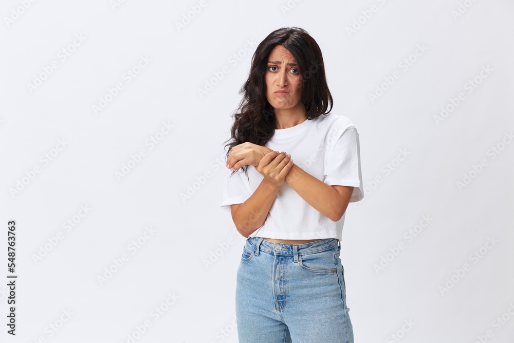 Woman pain in her arm, wrist sprain, bruised elbow in a white t-shirt on a white background, copy space Woman pain in her arm, wrist sprain, bruised elbow in a white t-shirt on a white background, copy space