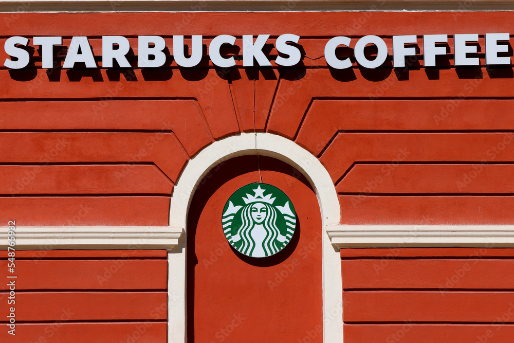 The logo sign of Starbucks Corporation is visible on a building in