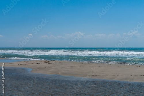 Fethiye  Turkey. Coast of Mediterranean Sea. Turquoise foamy waves. Sand beach. Close-up. Sunny autumn day.